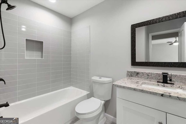 full bathroom with ceiling fan, toilet, vanity, and tiled shower / bath combo