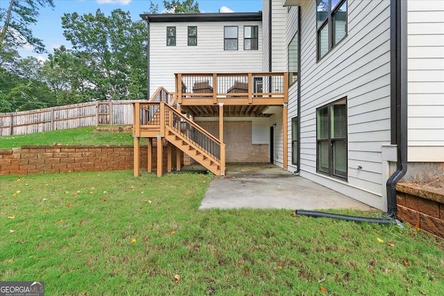 back of property featuring a lawn, a deck, and a patio