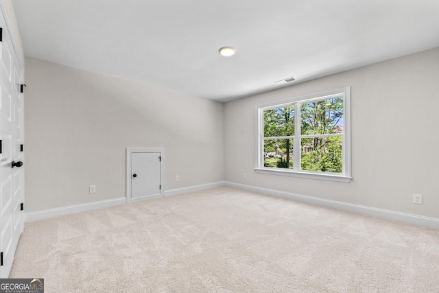 unfurnished room featuring light colored carpet