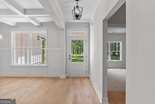 entryway with beamed ceiling, ornamental molding, a chandelier, and coffered ceiling