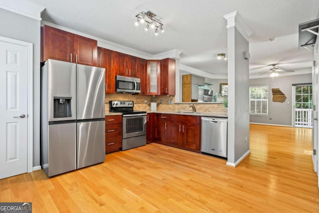 kitchen with stainless steel appliances, light hardwood / wood-style flooring, tasteful backsplash, and sink