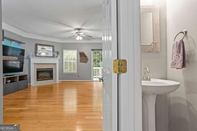 bathroom featuring wood-type flooring, a textured ceiling, ceiling fan, and crown molding