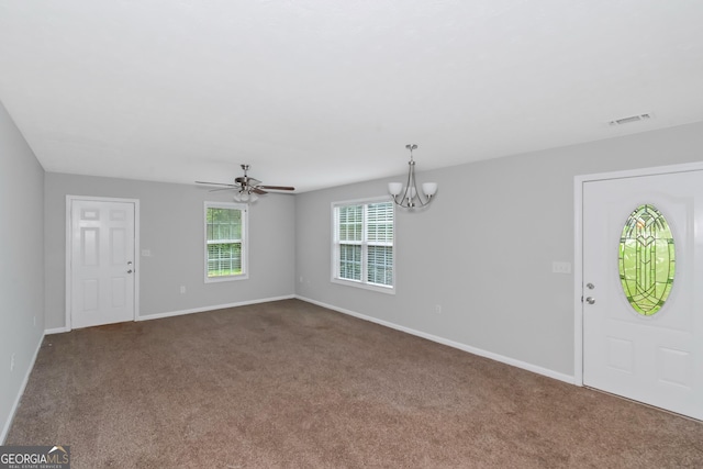 carpeted foyer with ceiling fan with notable chandelier