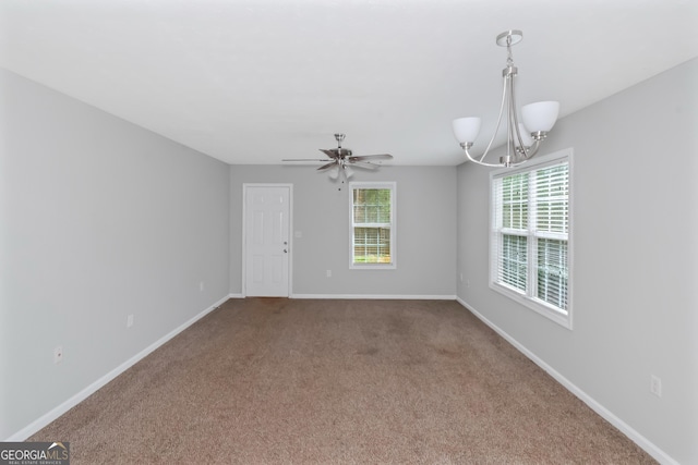 carpeted empty room with ceiling fan with notable chandelier