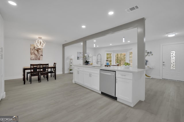 kitchen with dishwasher, white cabinets, hanging light fixtures, and light wood-type flooring