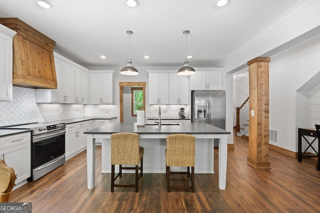 kitchen featuring white cabinets, a kitchen island with sink, and appliances with stainless steel finishes