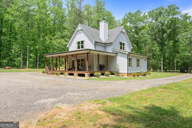 farmhouse featuring covered porch and a front lawn