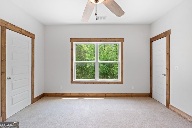 carpeted spare room featuring ceiling fan