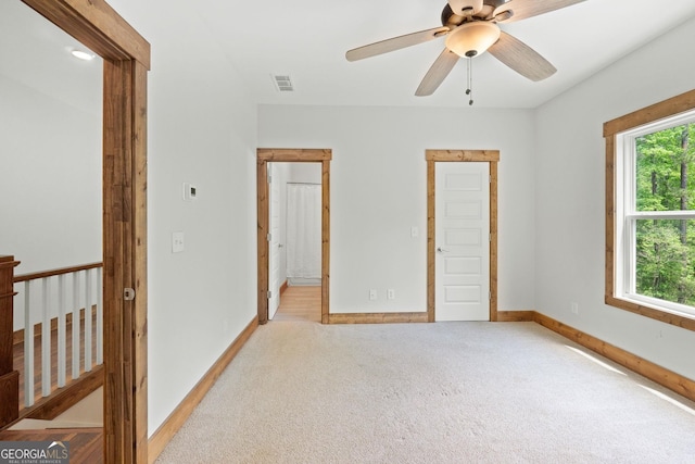 unfurnished bedroom featuring light colored carpet and ceiling fan