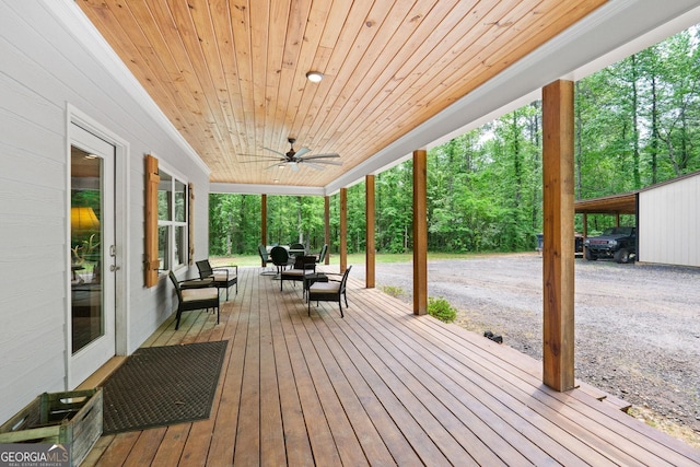 wooden terrace with a carport and ceiling fan