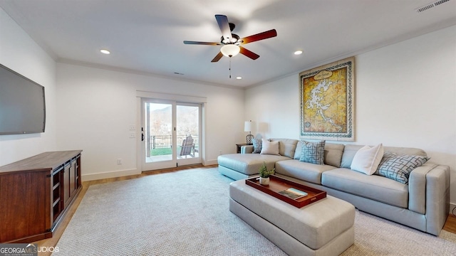 living room with ceiling fan and ornamental molding