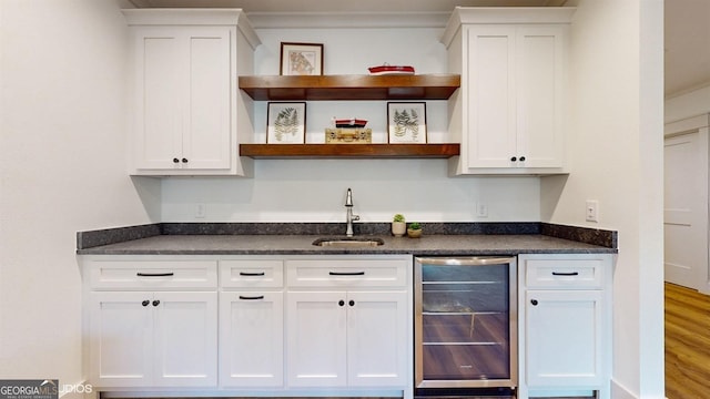 bar featuring white cabinetry, wine cooler, and sink