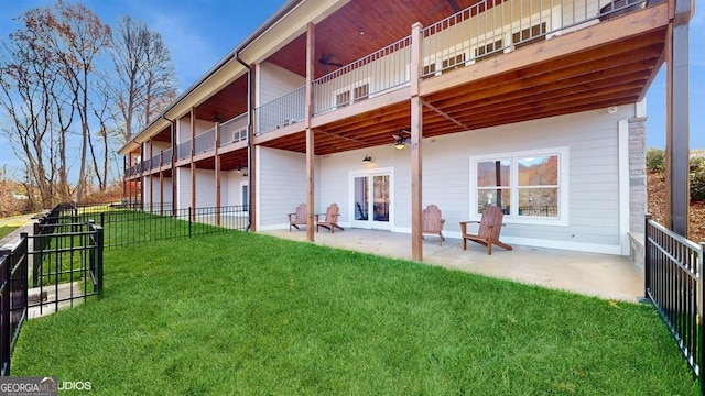 back of property with ceiling fan, a patio area, and a yard