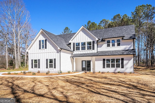 modern farmhouse featuring board and batten siding and roof with shingles