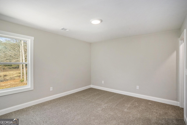 carpeted empty room featuring visible vents and baseboards