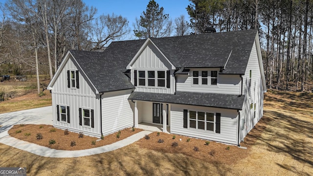 modern inspired farmhouse featuring board and batten siding, roof with shingles, driveway, and a chimney