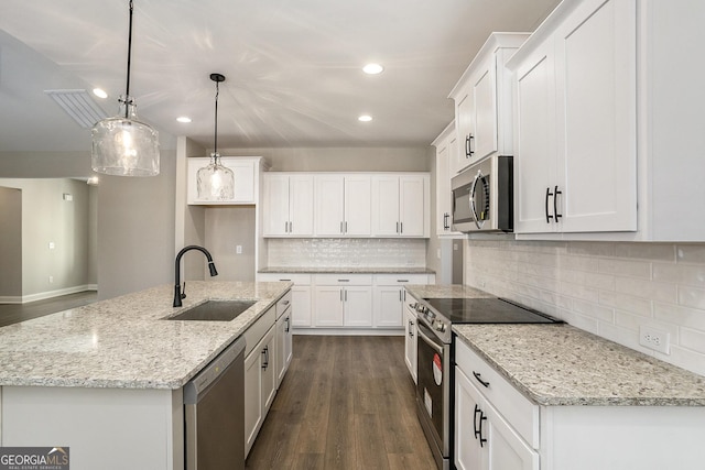 kitchen featuring appliances with stainless steel finishes, an island with sink, a sink, and white cabinetry