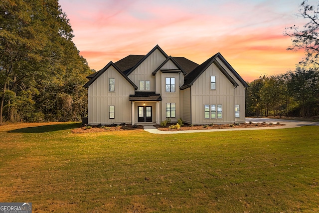 modern farmhouse style home featuring a lawn