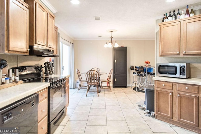 kitchen with black appliances, hanging light fixtures, ornamental molding, a notable chandelier, and light tile patterned flooring