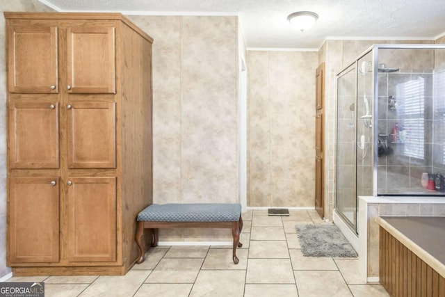 bathroom featuring tile patterned floors, a shower with shower door, a textured ceiling, and ornamental molding