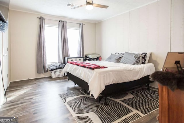 bedroom featuring ceiling fan, dark hardwood / wood-style flooring, and ornamental molding