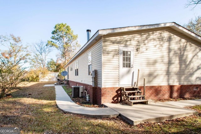 view of property exterior with central air condition unit and a patio