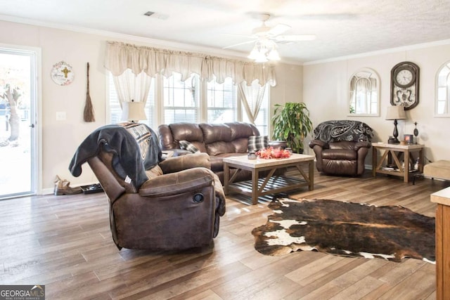 living room with crown molding, hardwood / wood-style floors, ceiling fan, and a textured ceiling