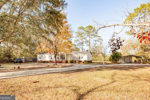 view of front facade featuring a front lawn, a garage, and a carport