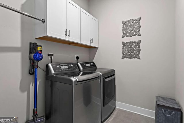 laundry area with washer and dryer, cabinets, and light tile patterned flooring