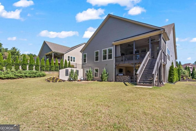 back of house featuring a lawn and ceiling fan