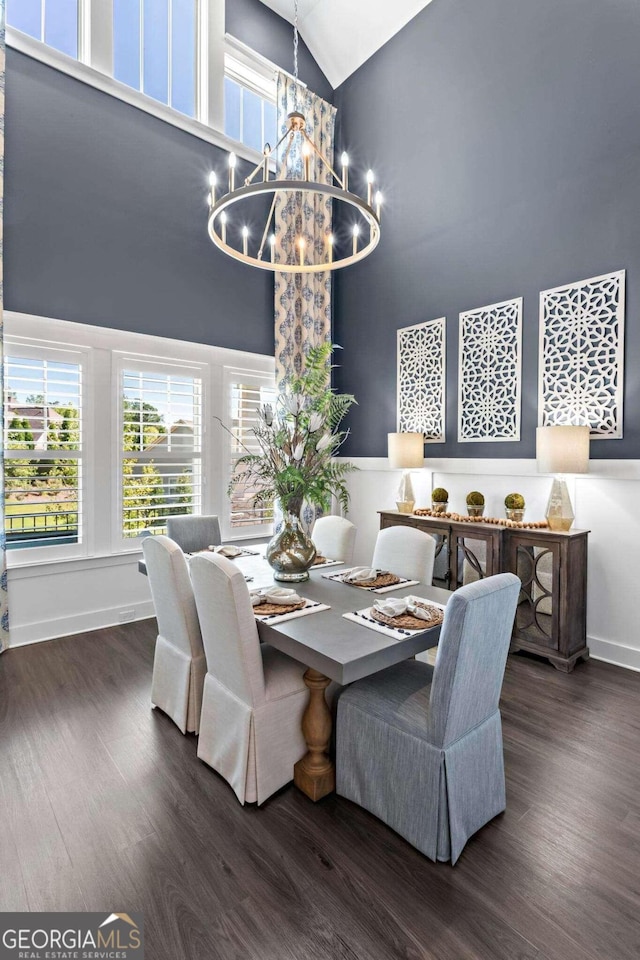 dining area with lofted ceiling, dark hardwood / wood-style flooring, and a notable chandelier