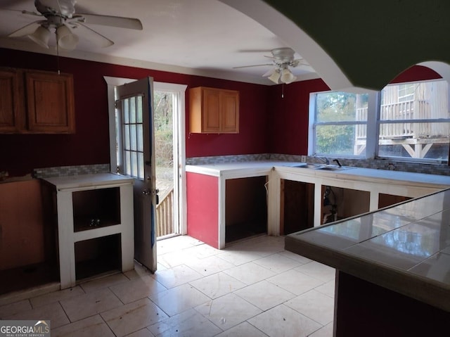 kitchen with decorative backsplash, tile countertops, ceiling fan, and sink