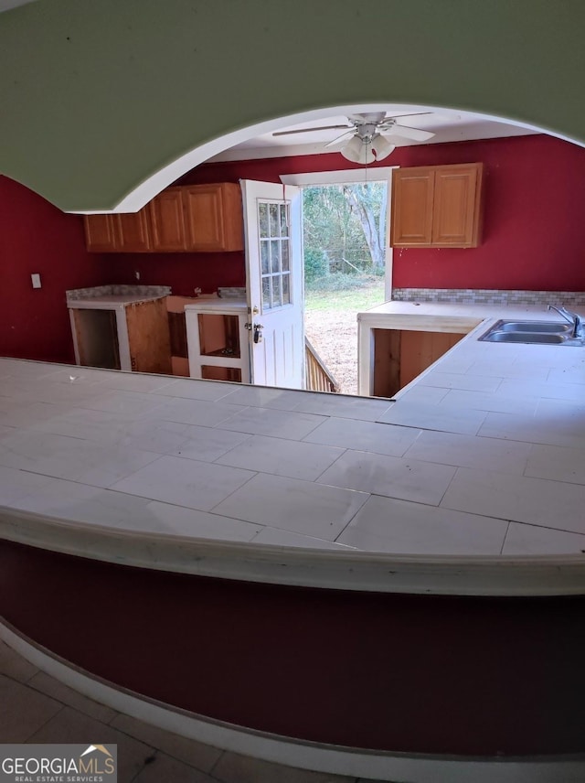 kitchen featuring tile patterned floors, ceiling fan, and sink