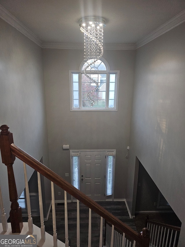 entryway featuring ornamental molding and a chandelier