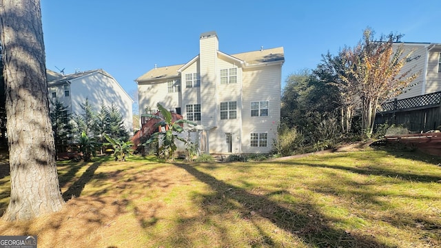 rear view of property featuring a yard