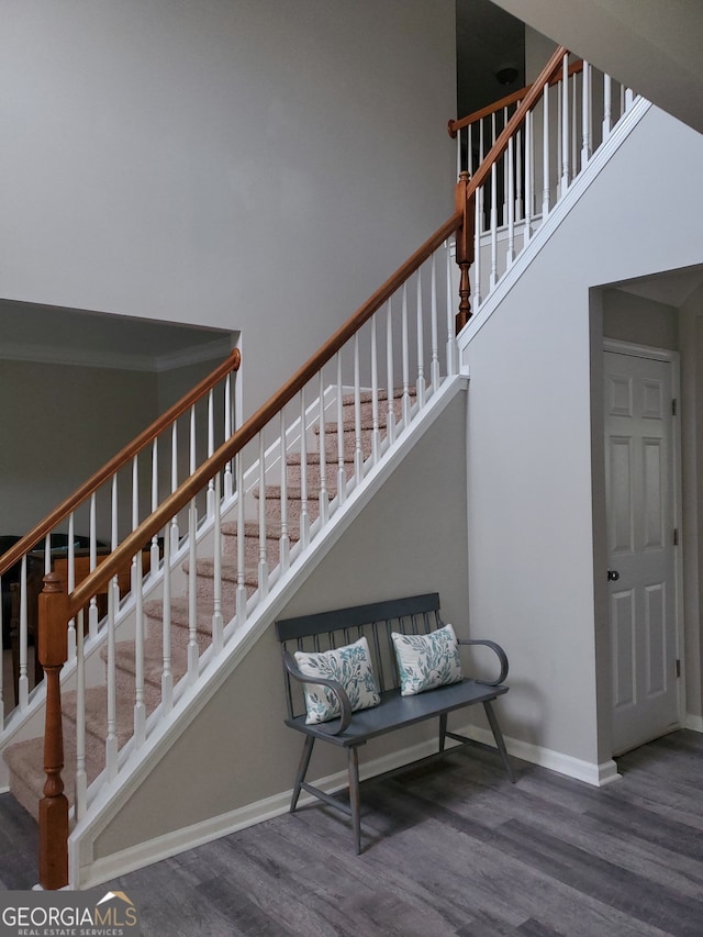 stairs featuring hardwood / wood-style floors and a towering ceiling