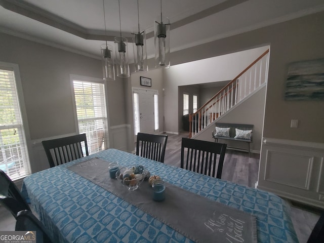 dining area featuring a raised ceiling, crown molding, and hardwood / wood-style floors