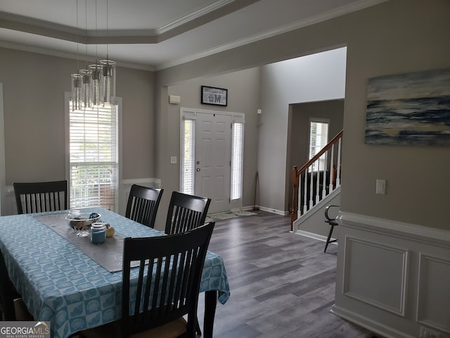 dining room featuring a chandelier, crown molding, a raised ceiling, and hardwood / wood-style floors