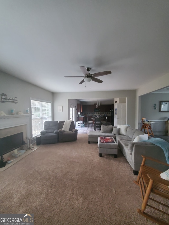 carpeted living room with ceiling fan