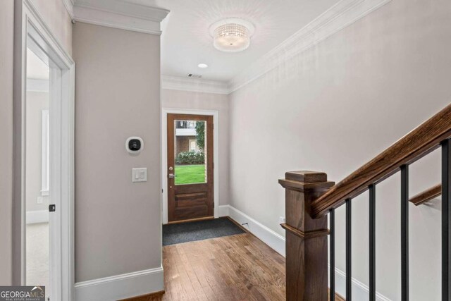 entrance foyer with hardwood / wood-style flooring and ornamental molding