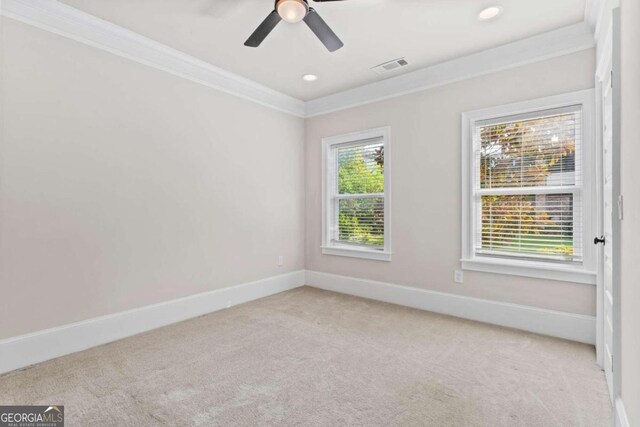 unfurnished room with ceiling fan, crown molding, and light carpet