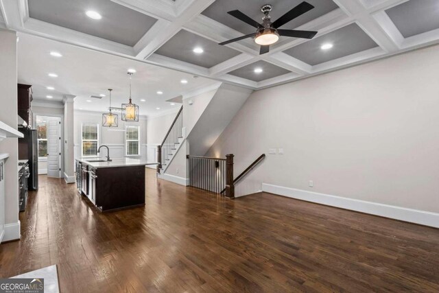 kitchen with dark hardwood / wood-style flooring, a center island with sink, pendant lighting, and coffered ceiling