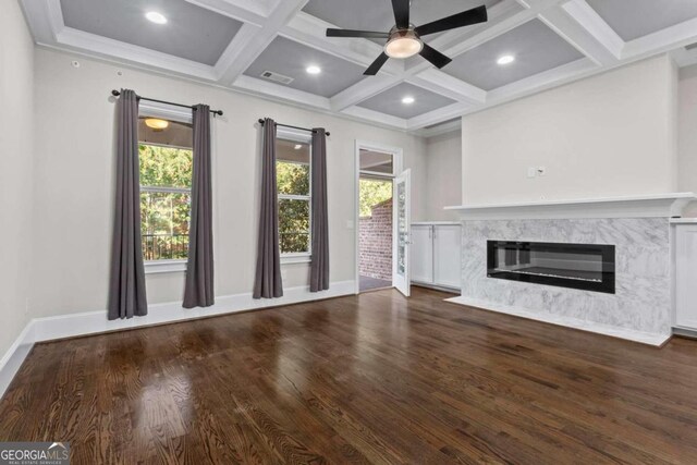 unfurnished living room featuring beam ceiling, ceiling fan, coffered ceiling, a premium fireplace, and dark hardwood / wood-style floors