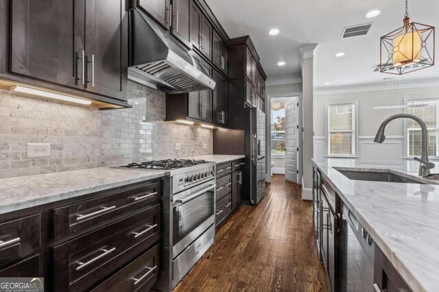 kitchen with sink, hanging light fixtures, backsplash, crown molding, and appliances with stainless steel finishes