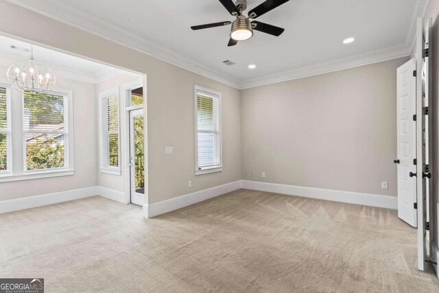 carpeted empty room featuring ceiling fan with notable chandelier and ornamental molding