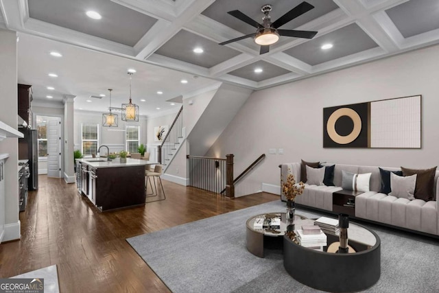 living room featuring dark hardwood / wood-style flooring, ceiling fan, coffered ceiling, and sink