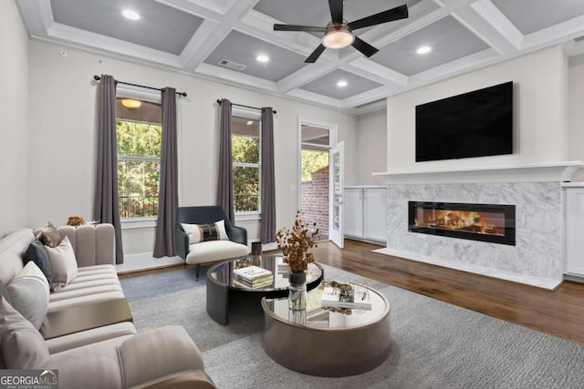 living room featuring dark hardwood / wood-style floors, plenty of natural light, a fireplace, and coffered ceiling