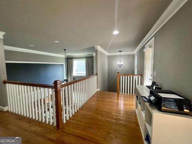 hallway featuring crown molding, hardwood / wood-style floors, and an inviting chandelier