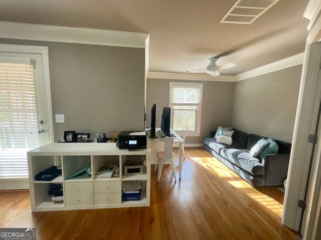 home office with ceiling fan, light hardwood / wood-style floors, and ornamental molding