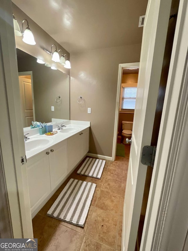 bathroom featuring tile patterned floors, vanity, and toilet